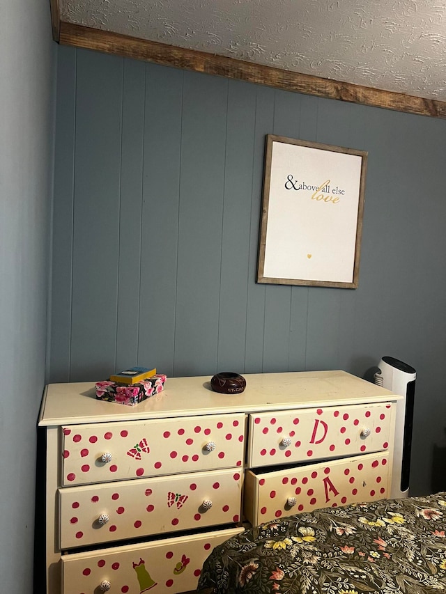 bedroom featuring wood walls and a textured ceiling