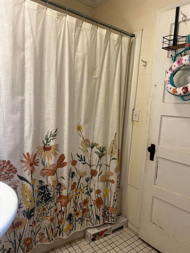 bathroom with curtained shower and tile patterned floors