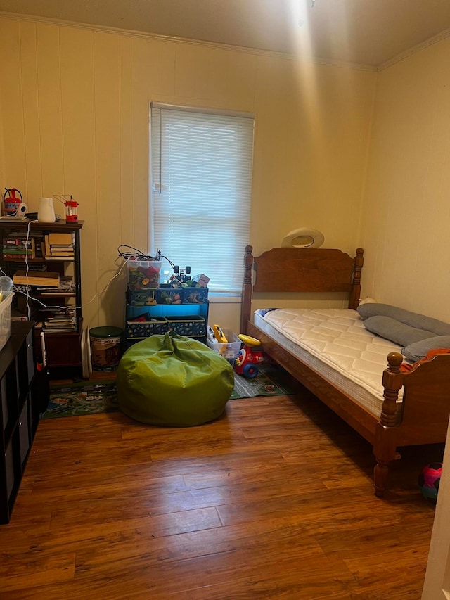 bedroom with ornamental molding and hardwood / wood-style flooring