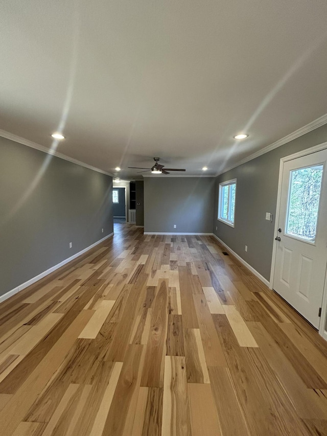 unfurnished living room featuring light hardwood / wood-style flooring, ceiling fan, and ornamental molding