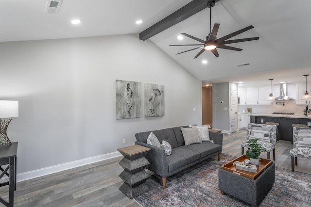 living room with ceiling fan, vaulted ceiling with beams, and hardwood / wood-style flooring