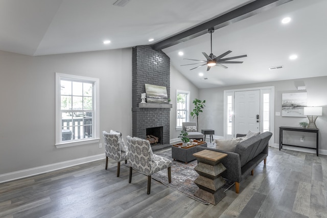 living room with ceiling fan, beam ceiling, dark wood-type flooring, high vaulted ceiling, and a fireplace