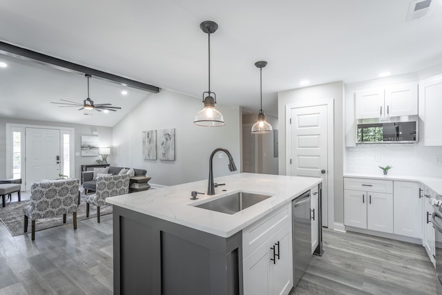 kitchen with an island with sink, white cabinets, appliances with stainless steel finishes, and sink