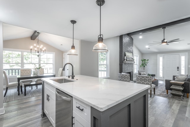 kitchen with vaulted ceiling with beams, decorative light fixtures, sink, and white cabinetry