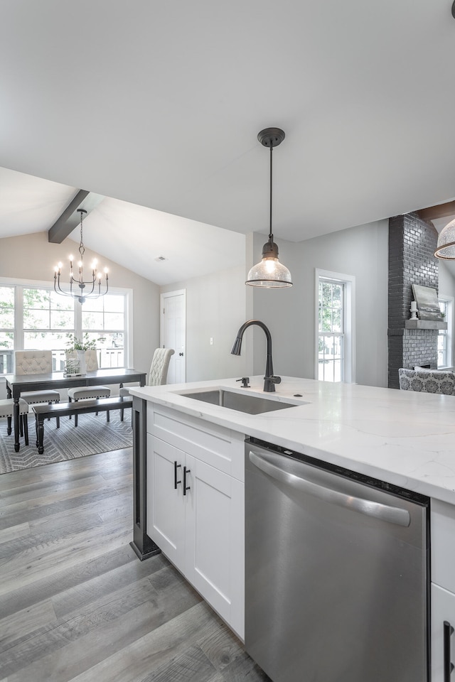 kitchen featuring hanging light fixtures, hardwood / wood-style flooring, white cabinetry, and stainless steel dishwasher