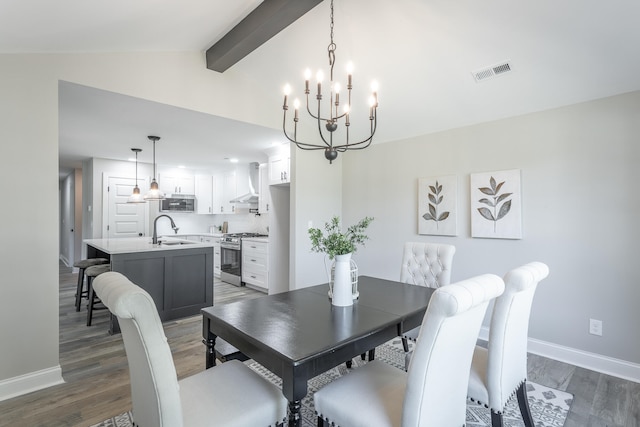 dining room with a notable chandelier, vaulted ceiling with beams, sink, and dark hardwood / wood-style floors