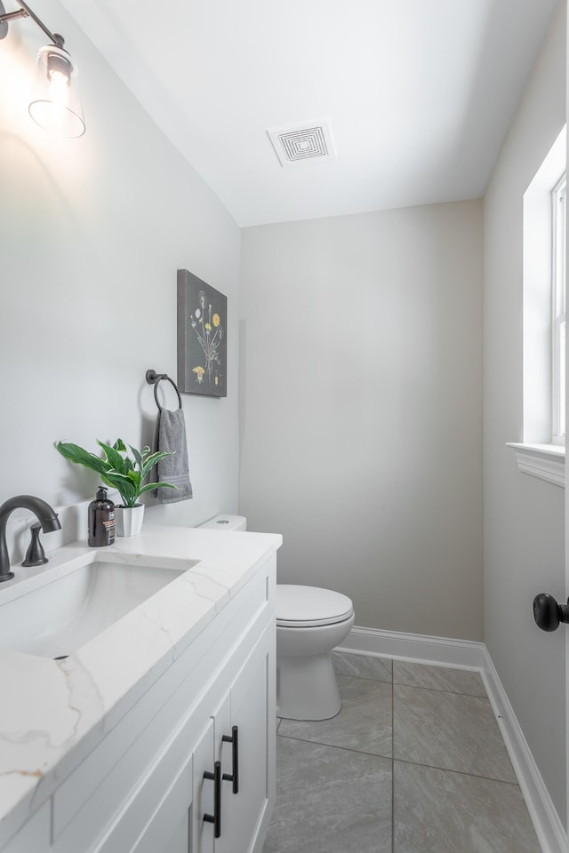 bathroom with vanity, tile patterned flooring, and toilet