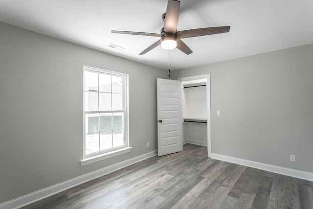 unfurnished bedroom with hardwood / wood-style flooring, ceiling fan, and a closet