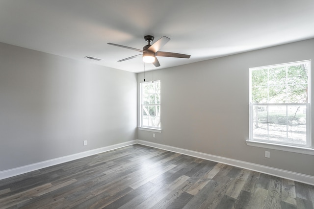 unfurnished room featuring ceiling fan, dark hardwood / wood-style floors, and a healthy amount of sunlight