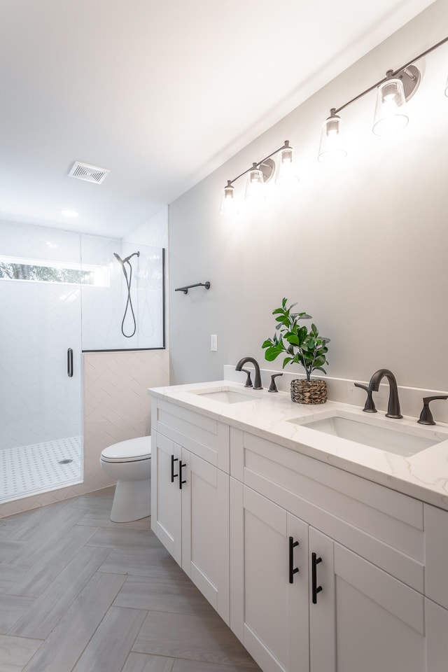 bathroom with walk in shower, vanity, and toilet