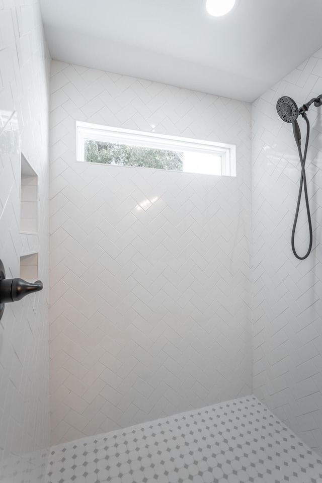 bathroom featuring a tile shower and plenty of natural light