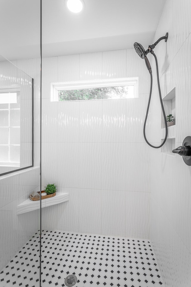 bathroom with tile patterned flooring, tiled shower, and tile walls