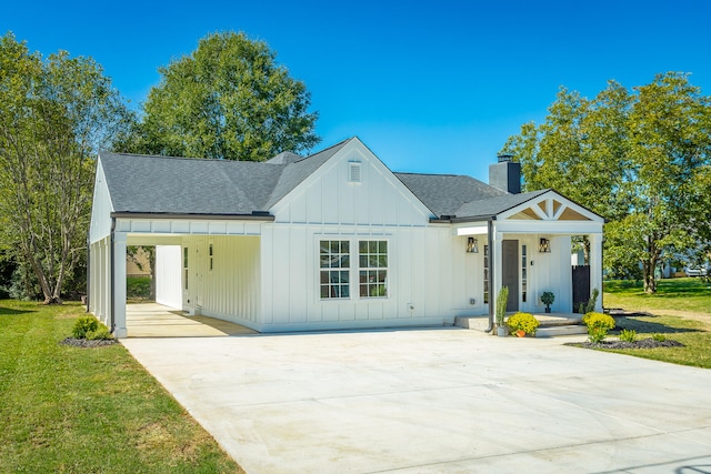 modern farmhouse with a carport, a front lawn, and covered porch