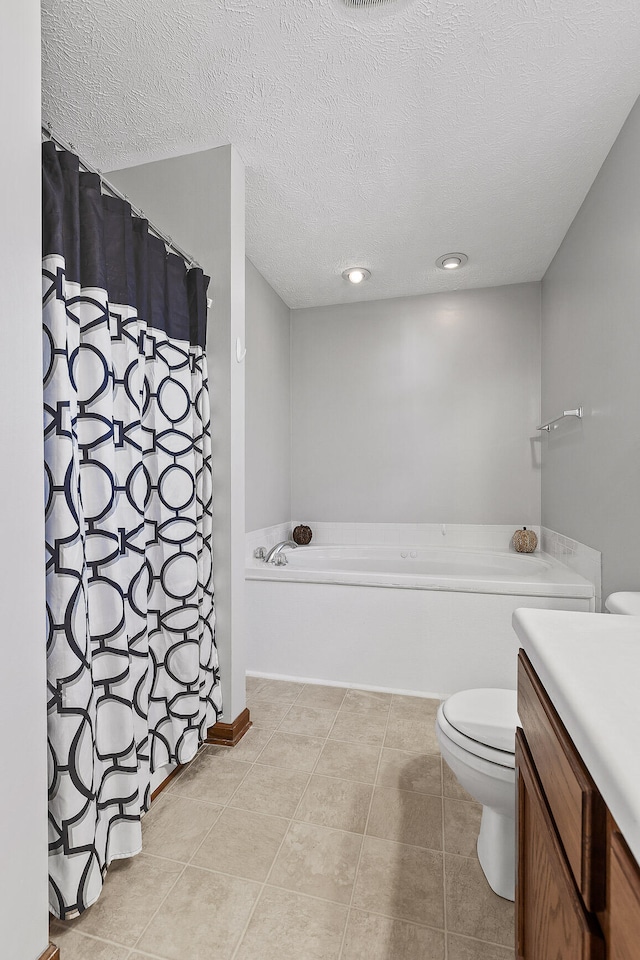 bathroom with tile patterned flooring, a textured ceiling, toilet, a bathtub, and vanity