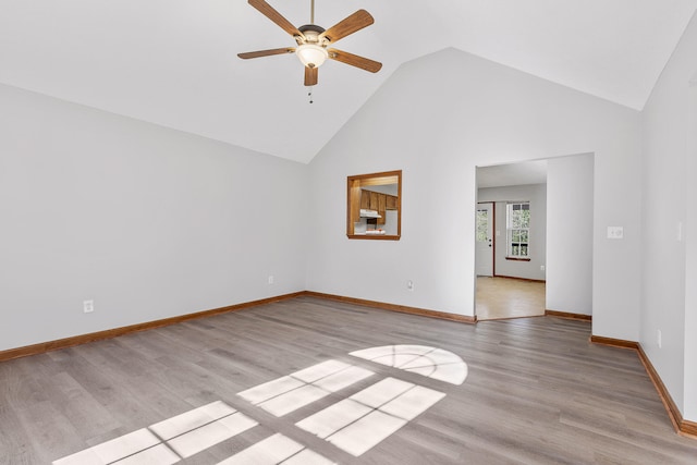 unfurnished room featuring light wood-type flooring, high vaulted ceiling, and ceiling fan