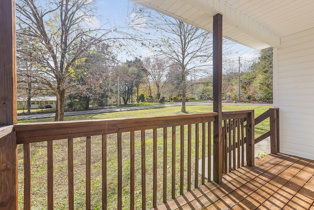 wooden deck featuring a lawn