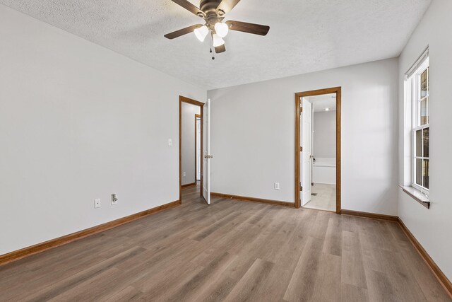 unfurnished room featuring a textured ceiling, light wood-type flooring, ceiling fan, and a healthy amount of sunlight