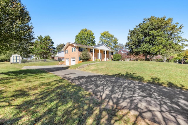 view of front of property with a front lawn, a storage shed, and a garage