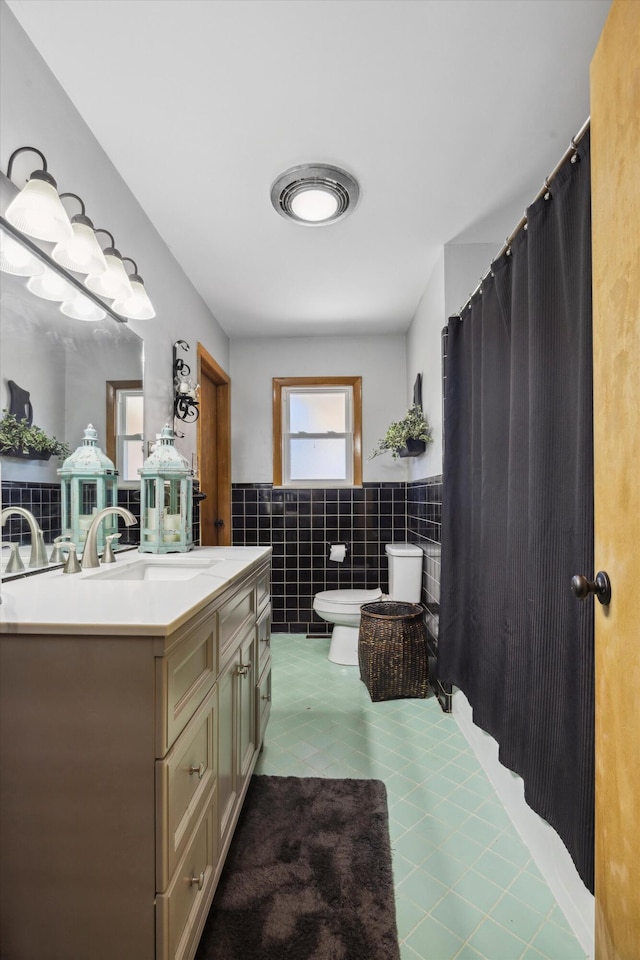 bathroom featuring vanity, tile walls, toilet, and tile patterned floors