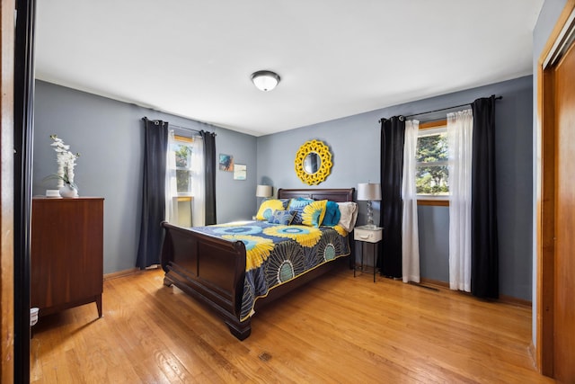 bedroom with multiple windows and light hardwood / wood-style floors