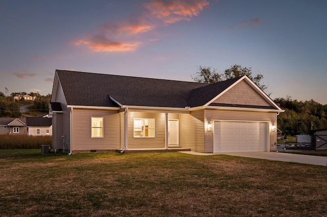 single story home featuring a garage and a yard