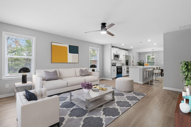 living room featuring ceiling fan and light hardwood / wood-style flooring