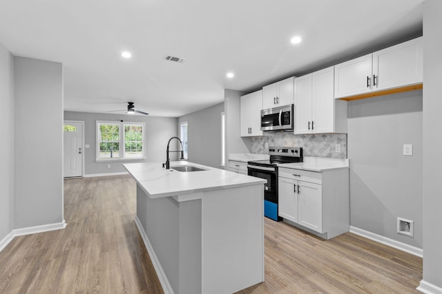 kitchen featuring white cabinetry, stainless steel appliances, and a kitchen island with sink