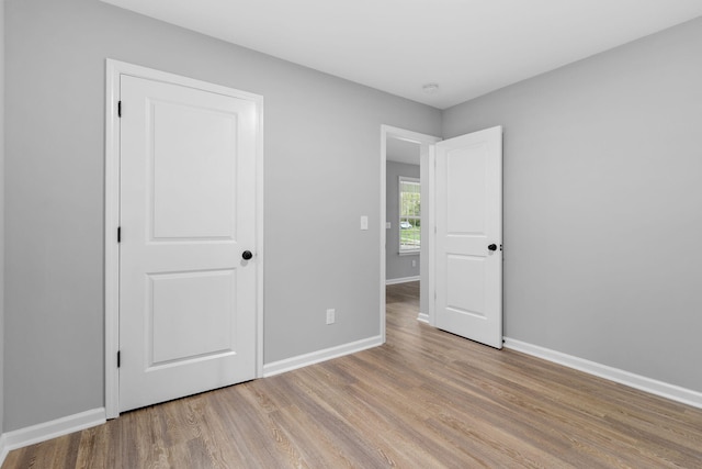 unfurnished bedroom with light hardwood / wood-style floors and a closet