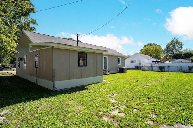 rear view of property with a yard and cooling unit