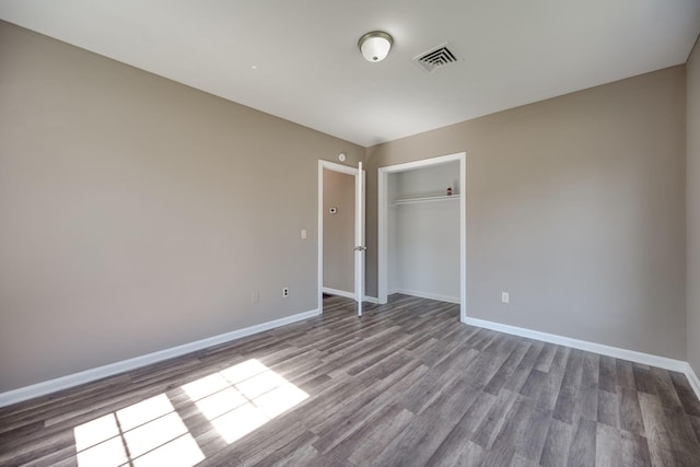 unfurnished bedroom featuring wood-type flooring and a closet