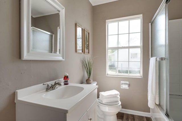 full bathroom featuring vanity, hardwood / wood-style flooring, toilet, ornamental molding, and shower / bath combination with glass door