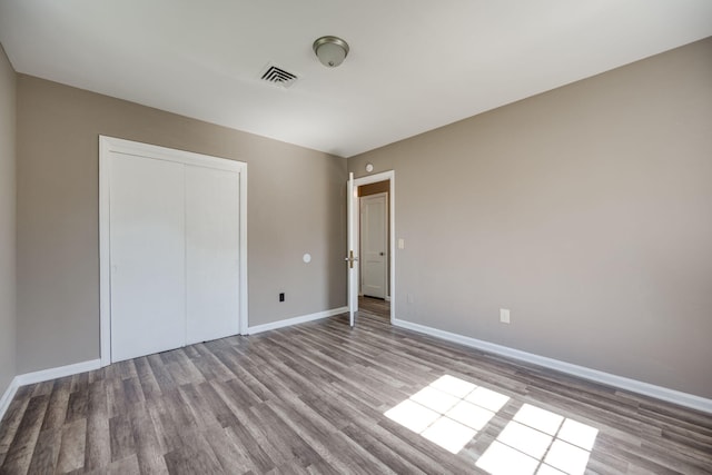 unfurnished bedroom with a closet and light hardwood / wood-style floors