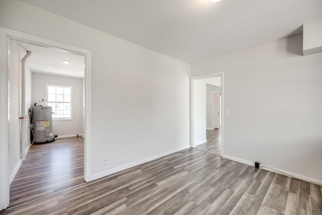 empty room with water heater and hardwood / wood-style flooring