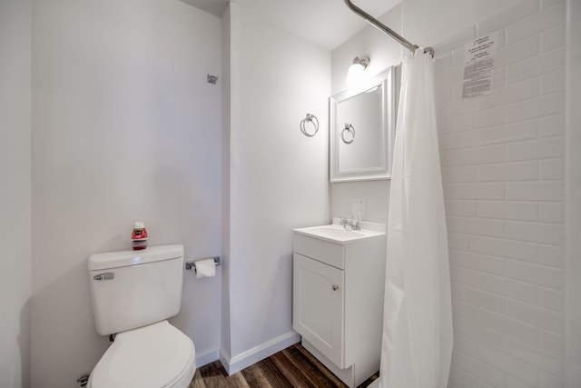 bathroom with hardwood / wood-style flooring, toilet, vanity, and curtained shower