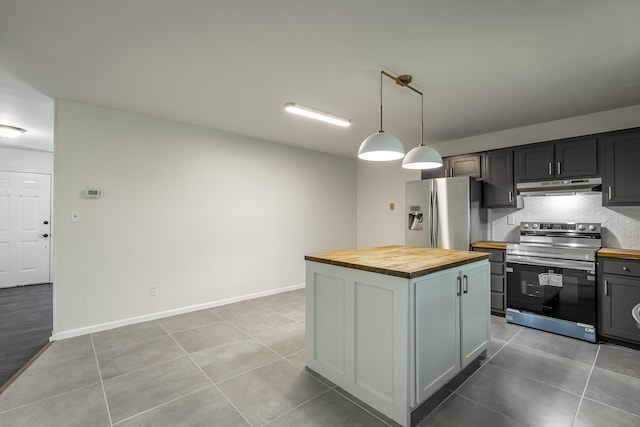 kitchen with pendant lighting, light tile patterned flooring, a kitchen island, appliances with stainless steel finishes, and wood counters