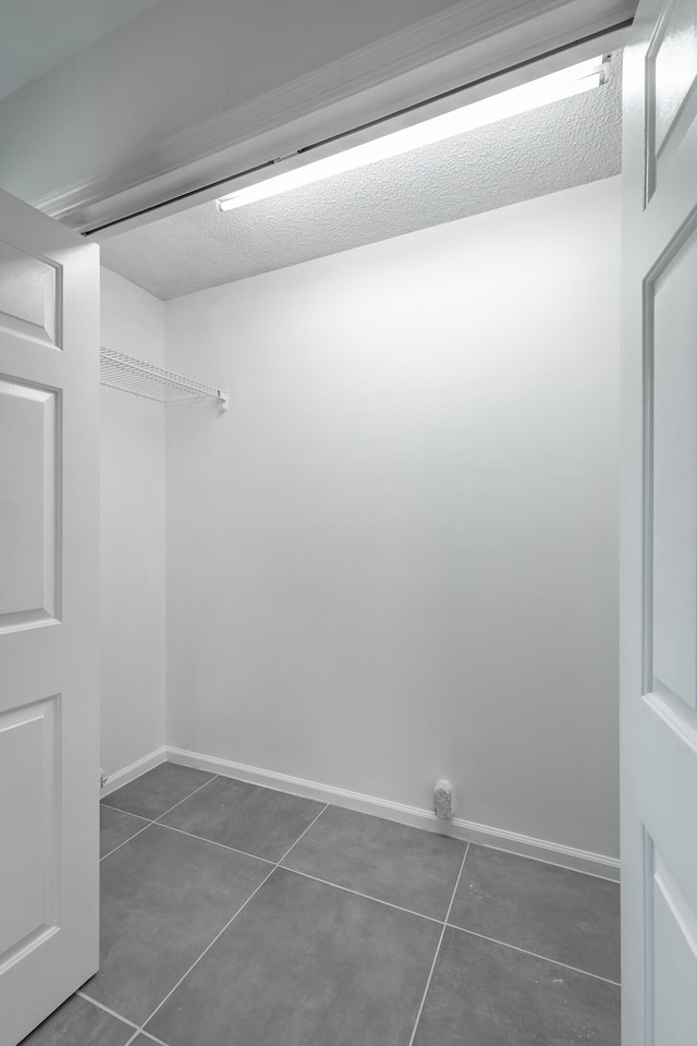 spacious closet with dark tile patterned floors