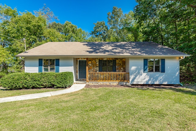 ranch-style house featuring covered porch and a front yard