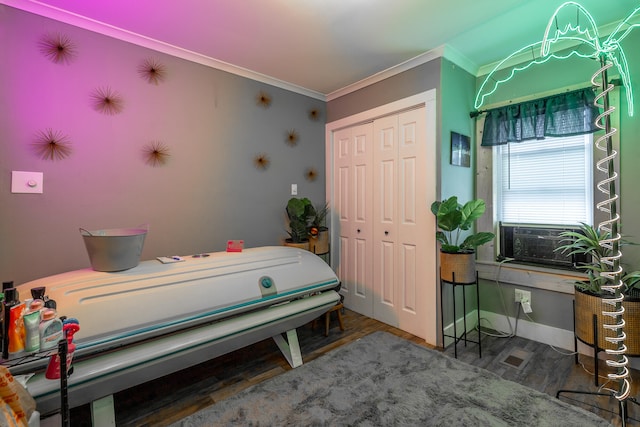 bedroom featuring hardwood / wood-style floors, cooling unit, crown molding, and a closet