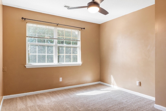 carpeted spare room featuring ceiling fan and a healthy amount of sunlight