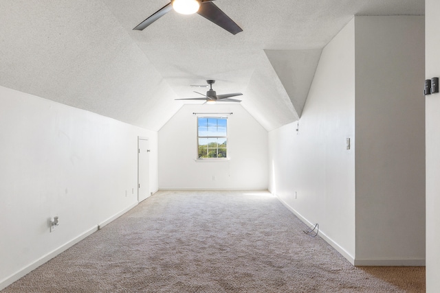 bonus room with lofted ceiling, ceiling fan, carpet floors, and a textured ceiling