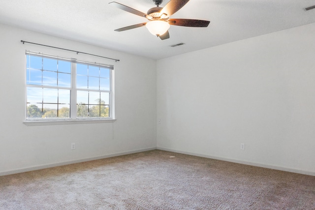 carpeted spare room featuring ceiling fan