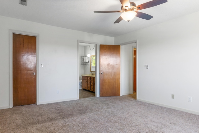 unfurnished bedroom with ceiling fan, connected bathroom, and light colored carpet