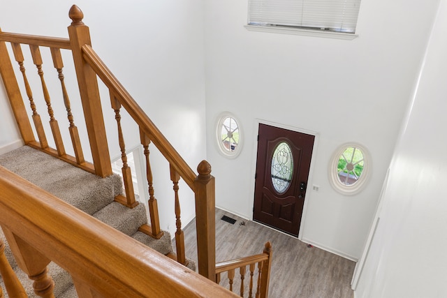 entryway with hardwood / wood-style flooring and a towering ceiling