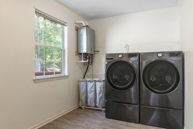 washroom with wood-type flooring, tankless water heater, and independent washer and dryer