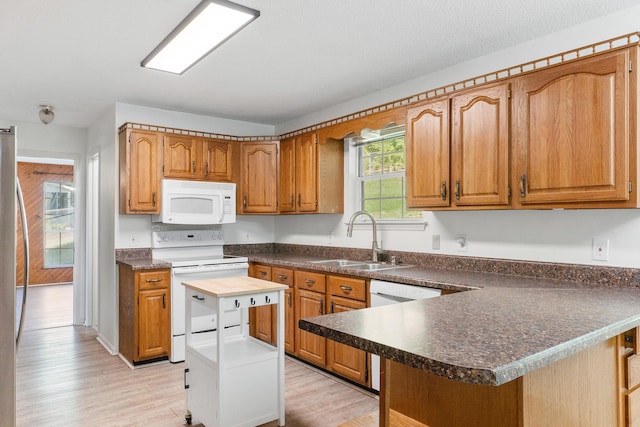 kitchen with plenty of natural light, sink, white appliances, and a kitchen island