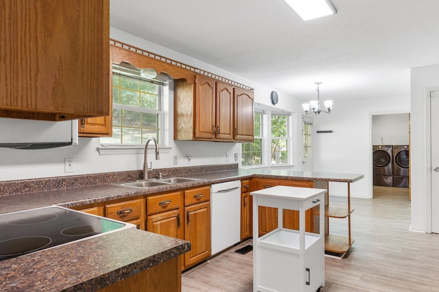 kitchen with washer and clothes dryer, a kitchen island, sink, dishwasher, and a wealth of natural light