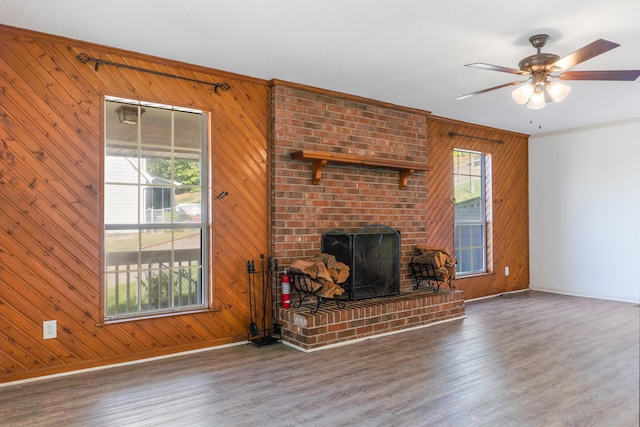 unfurnished living room featuring wood walls, dark hardwood / wood-style floors, and a wealth of natural light