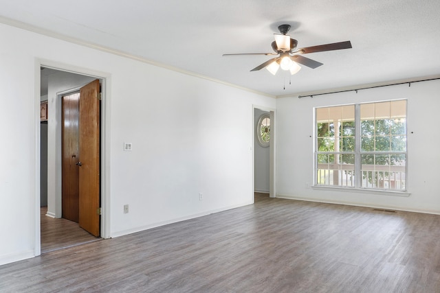 empty room with ornamental molding, hardwood / wood-style flooring, and ceiling fan