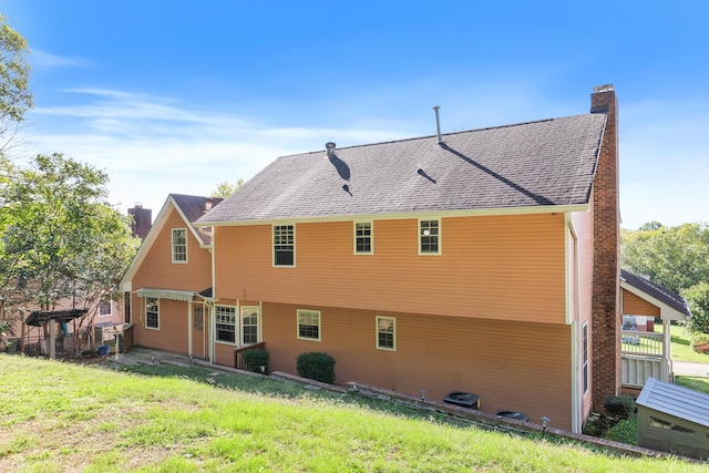 rear view of house featuring a yard