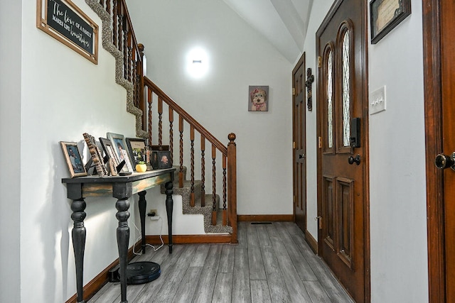 foyer entrance featuring vaulted ceiling and hardwood / wood-style floors